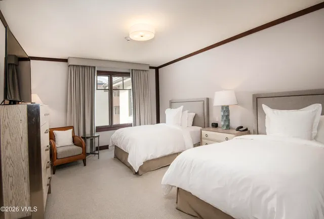 a bedroom with two beds and large window