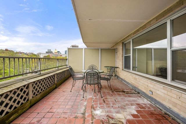 a balcony with table and chairs and wooden floor