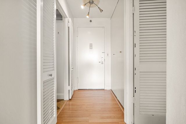 a view of a hallway with wooden floor and staircase