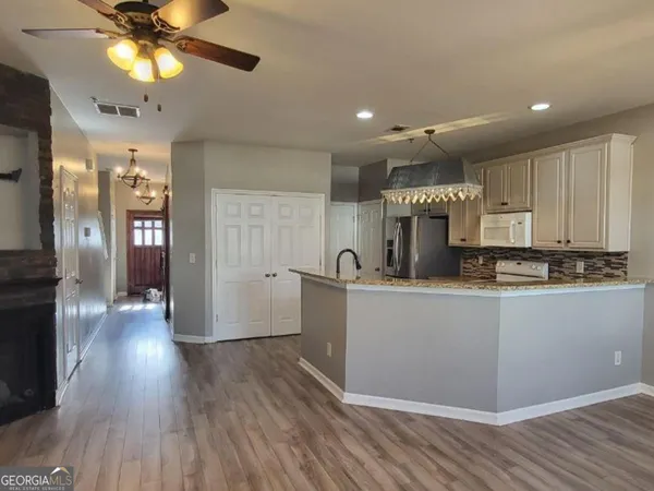 a kitchen with a wooden floor cabinets and stainless steel appliances