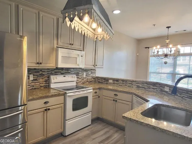 a kitchen with granite countertop a sink stainless steel appliances and cabinets