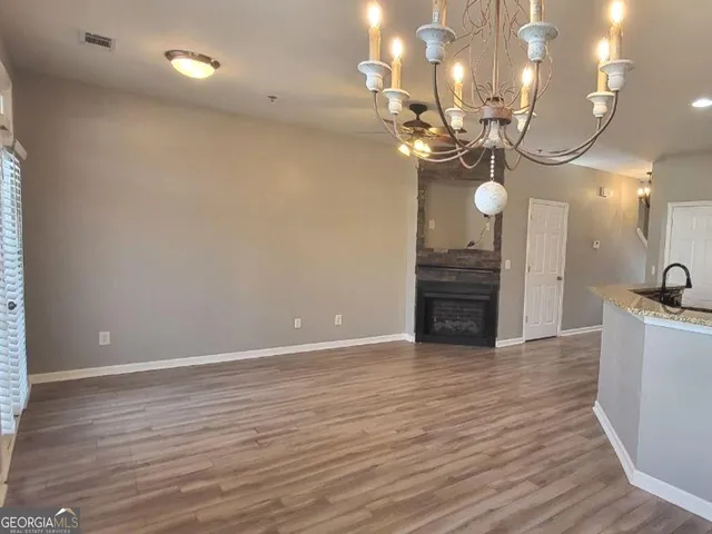 a view of a room with a chandelier and wooden floor