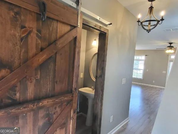 a view of a hallway with wooden floor and staircase