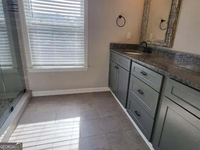 a bathroom with a granite countertop sink and a vanity