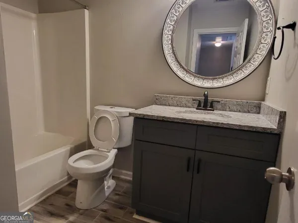 a bathroom with a toilet mirror vanity and sink