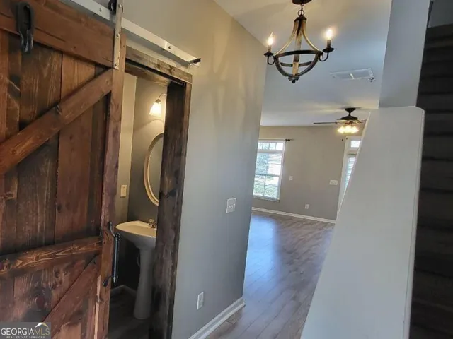 a view of a hallway with wooden floor and staircase