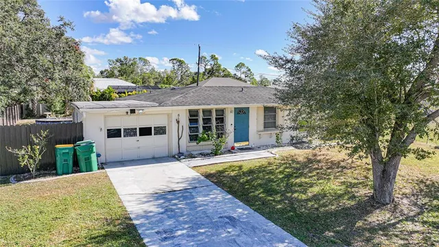 a front view of a house with a garden and trees