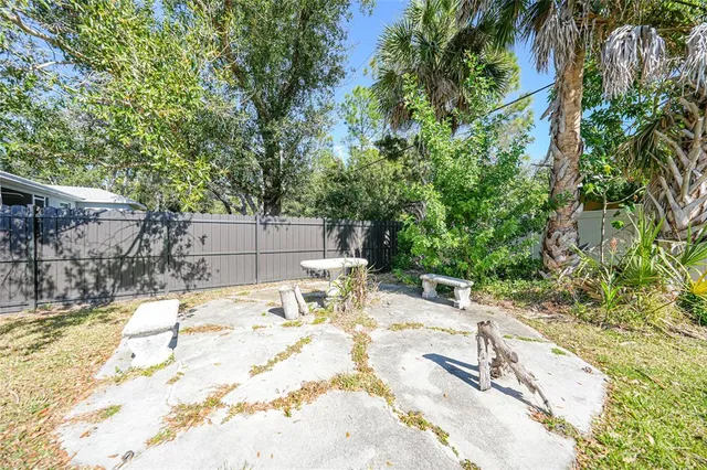 a view of backyard with a table and chairs and potted plants