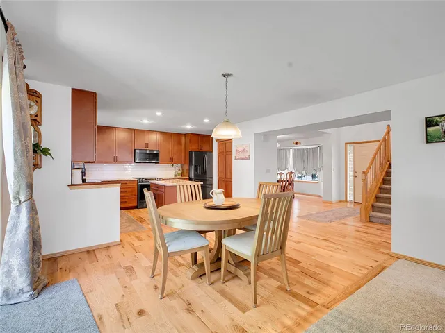 a dining room with furniture a chandelier and wooden floor