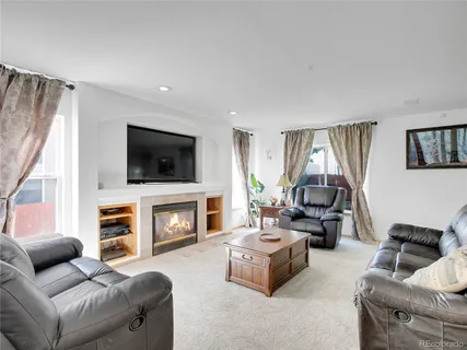 a living room with furniture a flat screen tv and a fireplace