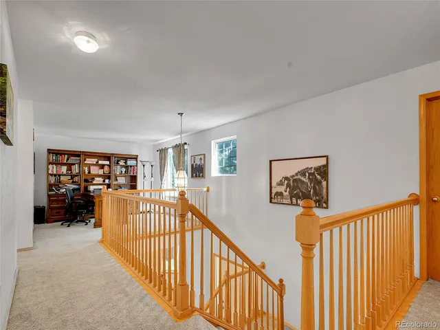 a view of a workspace with furniture and a window