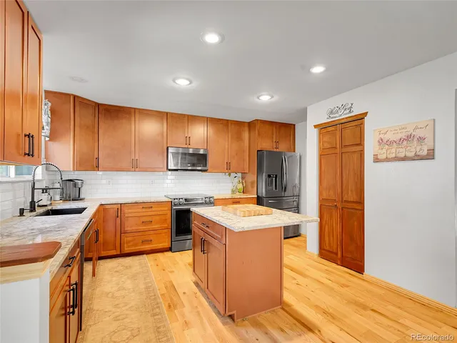 a kitchen with stainless steel appliances granite countertop refrigerator stove top oven sink and cabinets