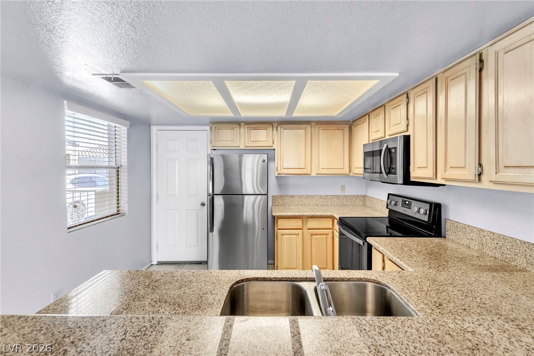 6250 West Flamingo Road, Unit 98 Las Vegas, NV 89103 - Photo 10 of 40 Kitchen featuring light brown cabinets, visible vents, a sink, and appliances with stainless steel finishes