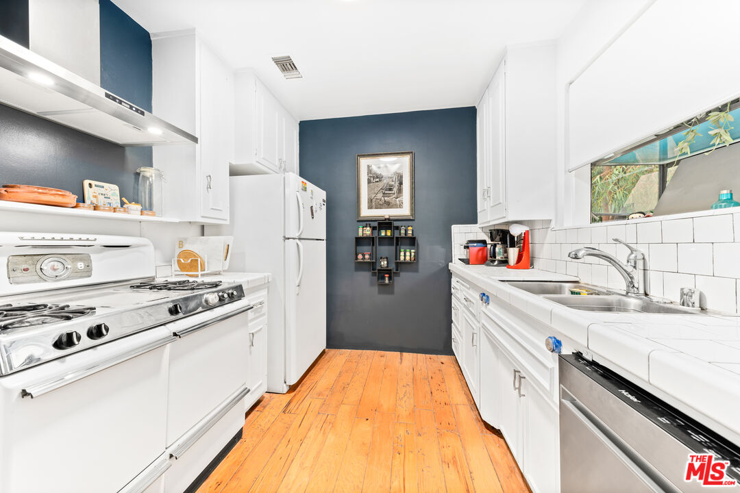1330 North Crescent Heights Boulevard, Unit 16 West Hollywood, CA 90046 - Photo 8 of 25 a kitchen with stainless steel appliances granite countertop a sink stove and refrigerator