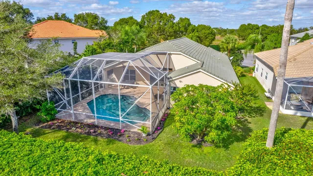 a backyard of a house with table and chairs under an umbrella