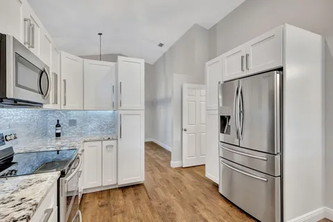 a kitchen with stainless steel appliances granite countertop a refrigerator sink and microwave