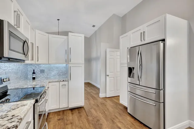 a kitchen with stainless steel appliances granite countertop a refrigerator sink and microwave