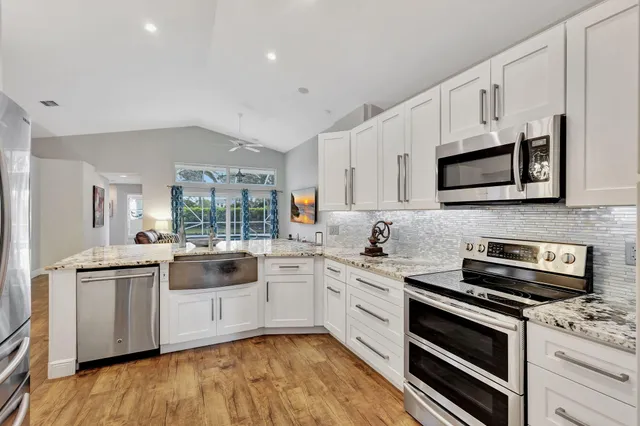 a kitchen with stainless steel appliances a stove sink microwave and cabinets