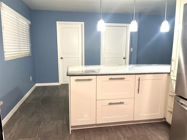 a bathroom with a granite countertop sink and washing machine