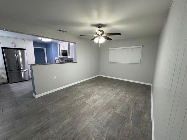a view of a livingroom with a ceiling fan window and a ceiling fan