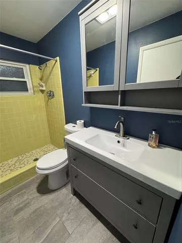 a bathroom with a sink a toilet and mirror