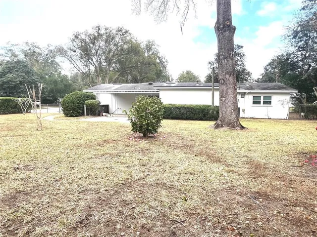 a view of a house with a yard and sitting area