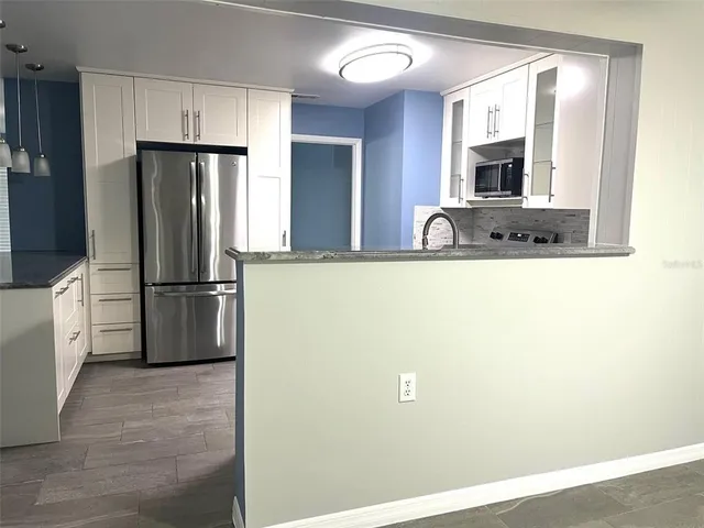 a kitchen with stainless steel appliances a refrigerator and microwave