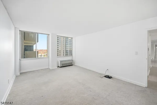 an empty room with entrance and windows