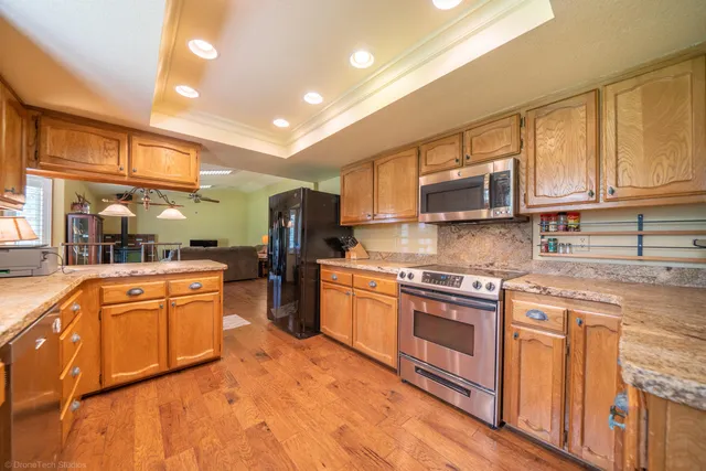 a kitchen with stainless steel appliances granite countertop a stove and cabinets