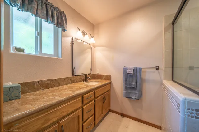 a bathroom with a granite countertop sink and a mirror
