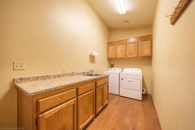 a utility room with cabinets washer and dryer