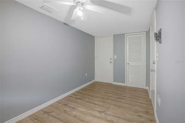 a view of an empty room with wooden floor