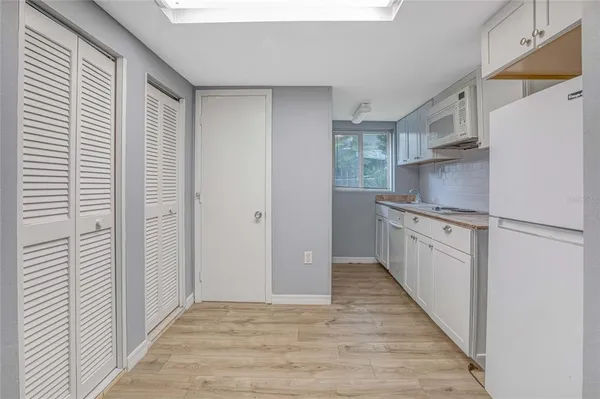 a kitchen with white cabinets and white appliances