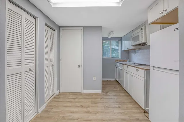 a kitchen with white cabinets and white appliances