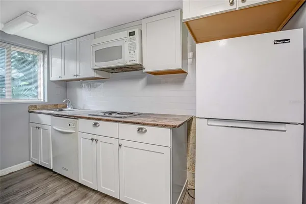a kitchen with stainless steel appliances white cabinets and a refrigerator