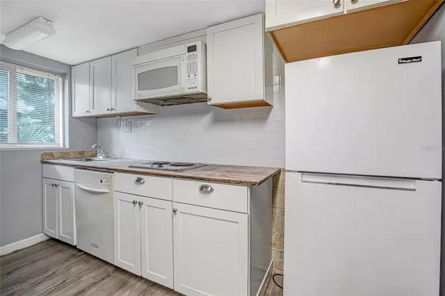 a kitchen with stainless steel appliances white cabinets and a refrigerator