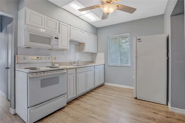 a kitchen with stainless steel appliances granite countertop a sink a stove a refrigerator and cabinets