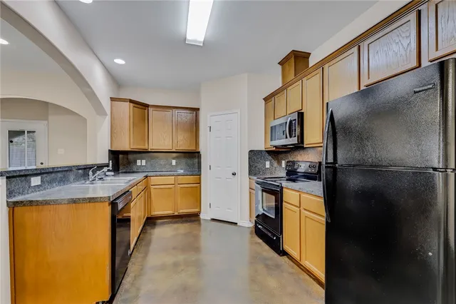 a kitchen with a refrigerator a stove top oven and a sink