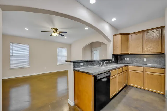 a kitchen with a sink a stove cabinets and counter space