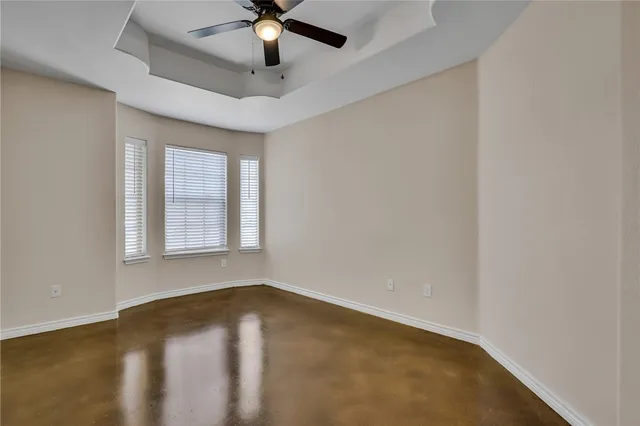 an empty room with a window and a ceiling fan