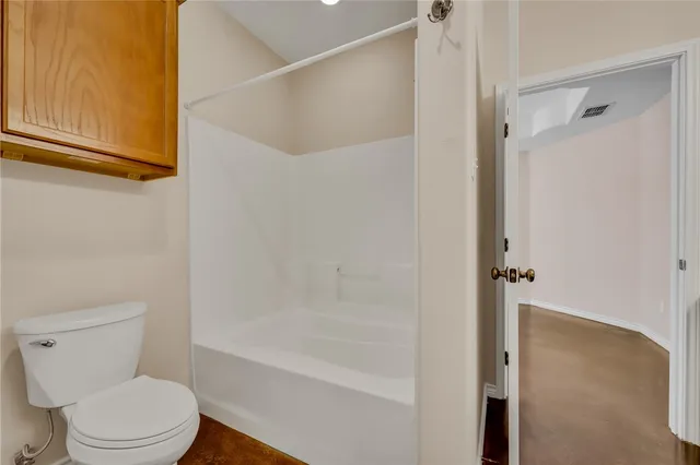 a bathroom with a toilet and a shower