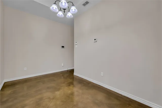 a view of an empty room with a chandelier fan