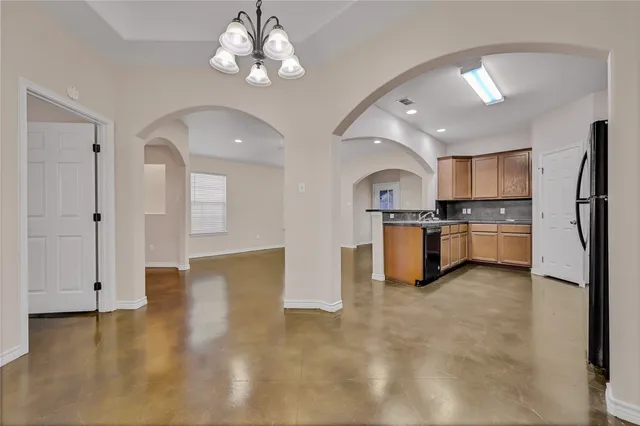 a view of a kitchen with stainless steel appliances granite countertop a stove cabinets and wooden floor