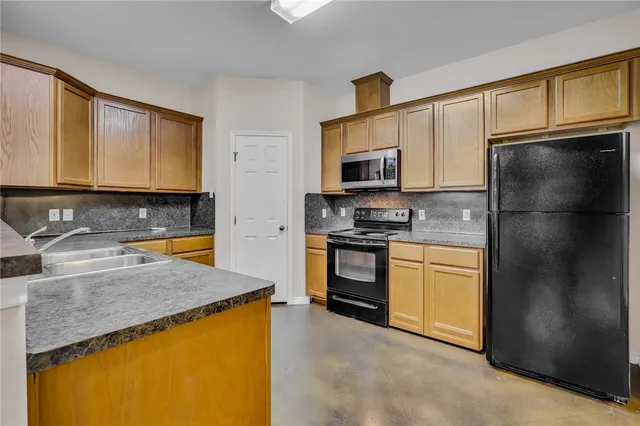 a kitchen with granite countertop stainless steel appliances and refrigerator
