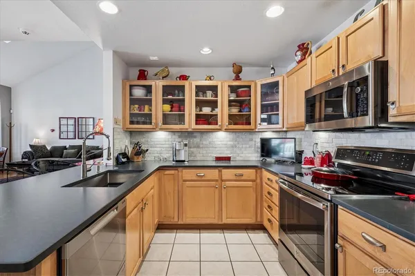 a kitchen with stainless steel appliances granite countertop a sink stove and cabinets