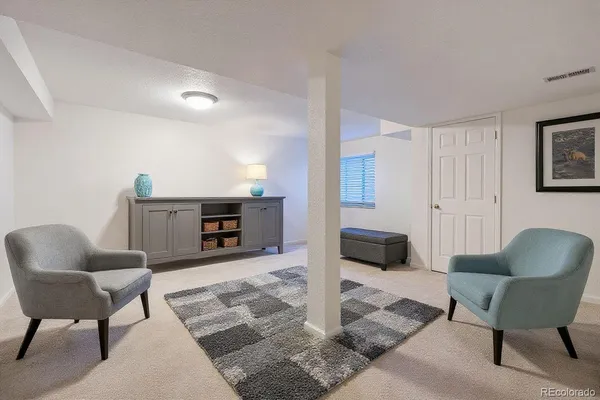 a bedroom with a bed chair and wooden floor
