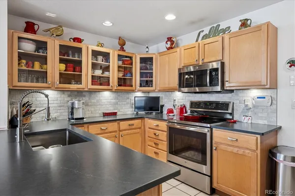a kitchen with stainless steel appliances wooden cabinets a stove a sink and a microwave