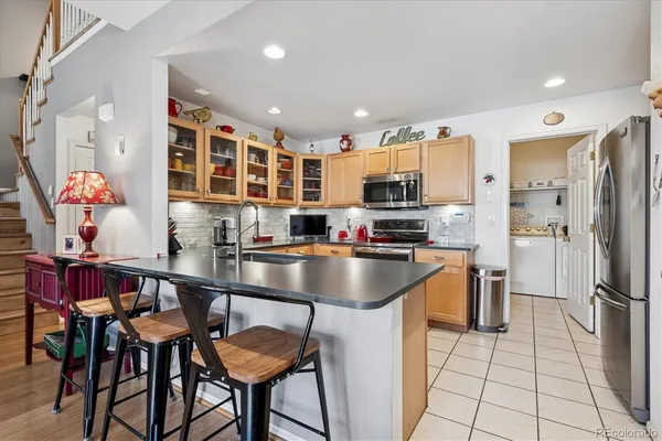 a kitchen with stainless steel appliances granite countertop a refrigerator and a stove top oven with wooden floor