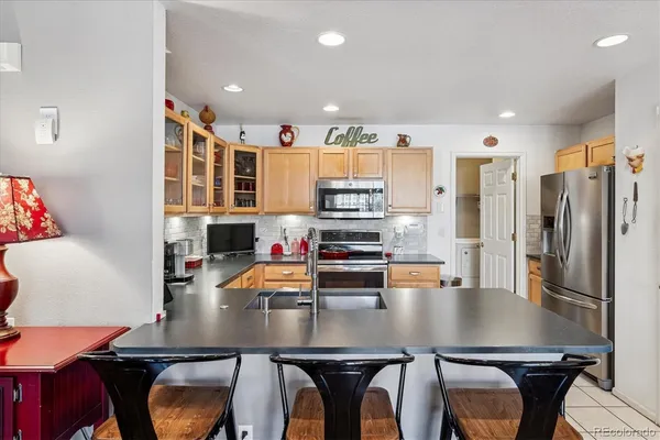 a kitchen with stainless steel appliances a table and chairs in it