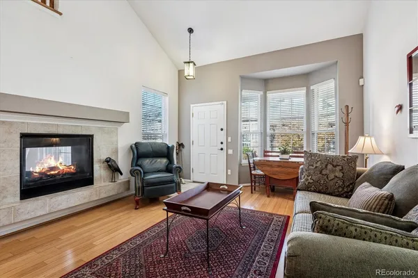a living room with furniture a large window and a fireplace